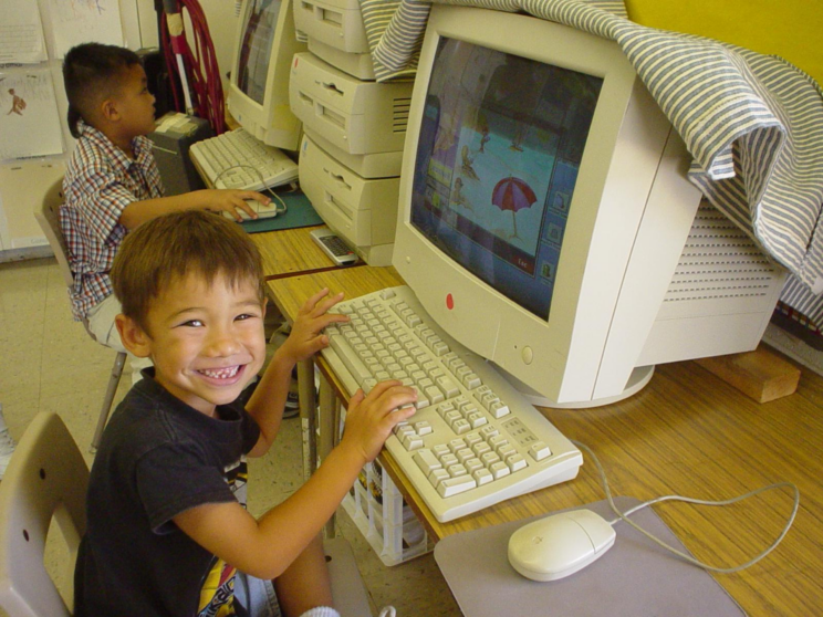 Two young boys at desktop computers.