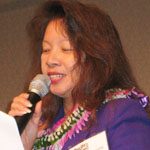 Suzanne_ChunOakland Suzanne Chun Oakland making a speech with lei around her neck.